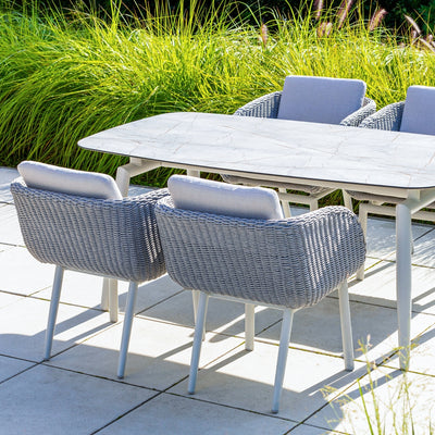 Sorrento Outdoor Aluminium Dining Table setup featuring the Sorrento Dining Chair by Couture Jardin, crafted with woven Olaphen rope and paired with a sleek dining table featuring a ceramic top. The chairs highlight their stylish curved design and comfortable cushions, creating a sophisticated and durable setting for patio or garden spaces.