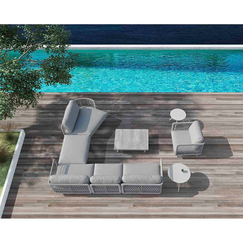 A modern outdoor living area featuring a large 6 seater sofa set in light grey, paired with a minimalist rectangular coffee table, beside a pool.